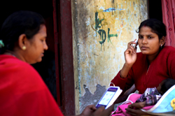 A Community Health Worker  counselling a new mother using Mobile Kunji